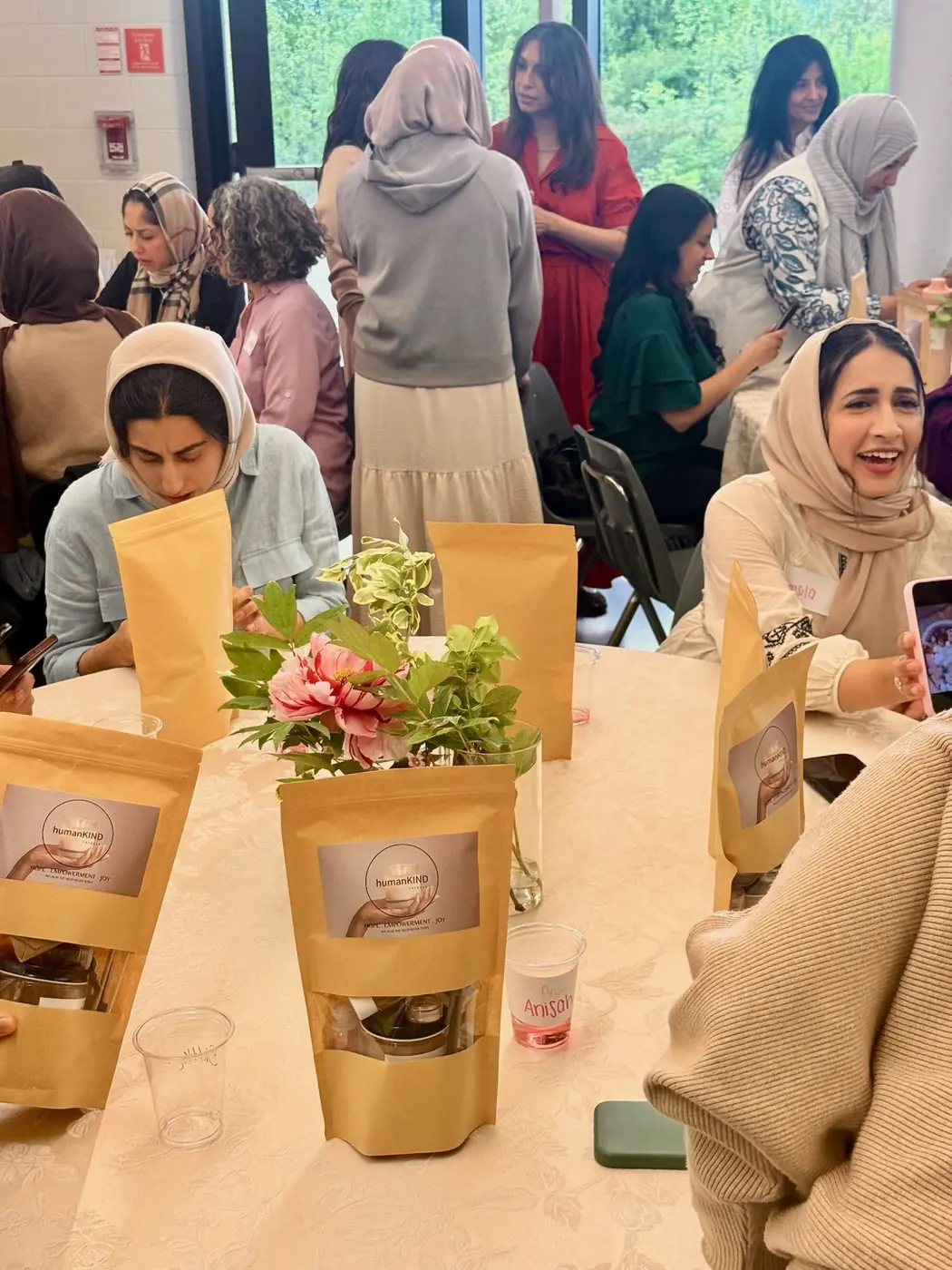 Women chatting and laughing around a decorated table at a community event