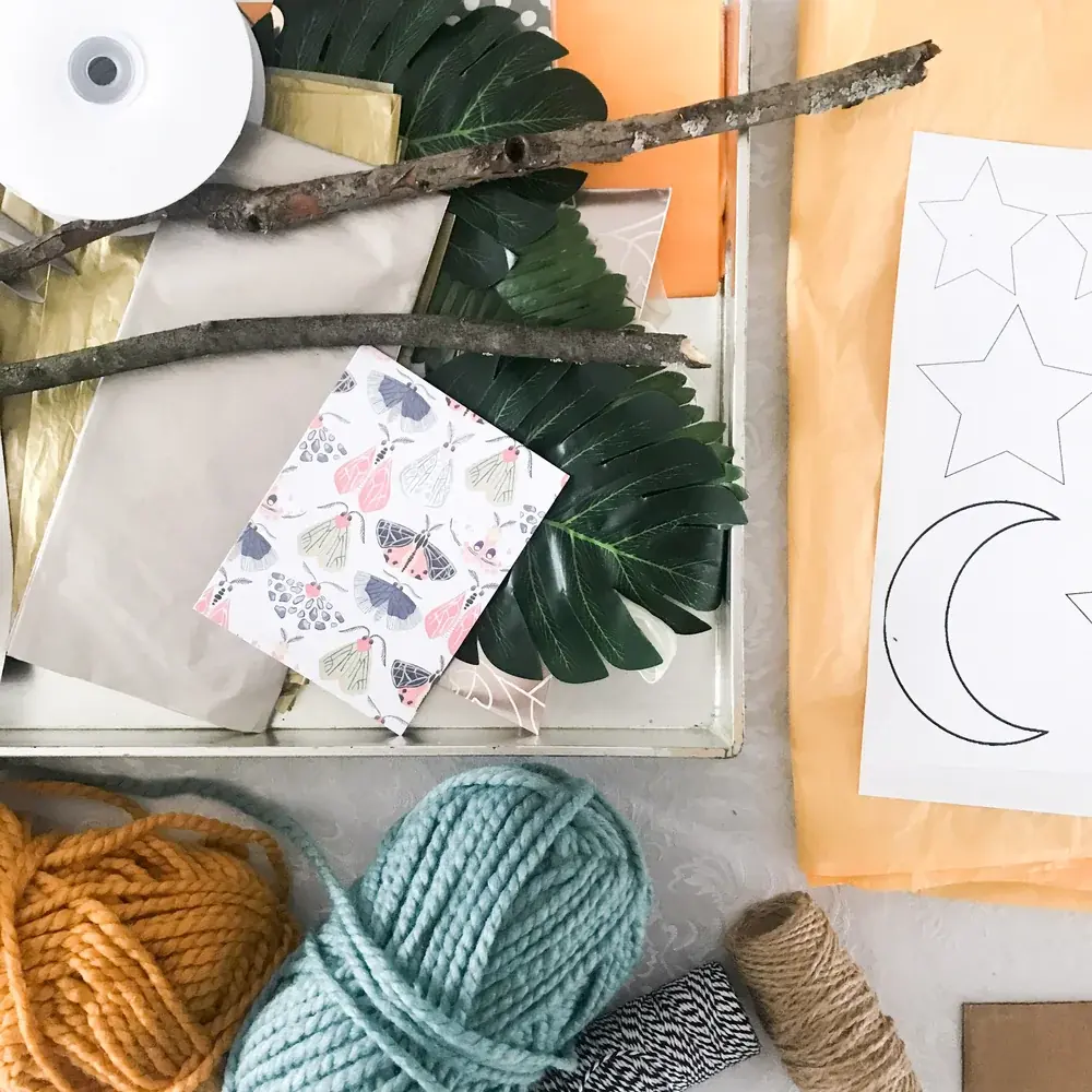Yarn, paper cutouts and craft supplies laid out on a table