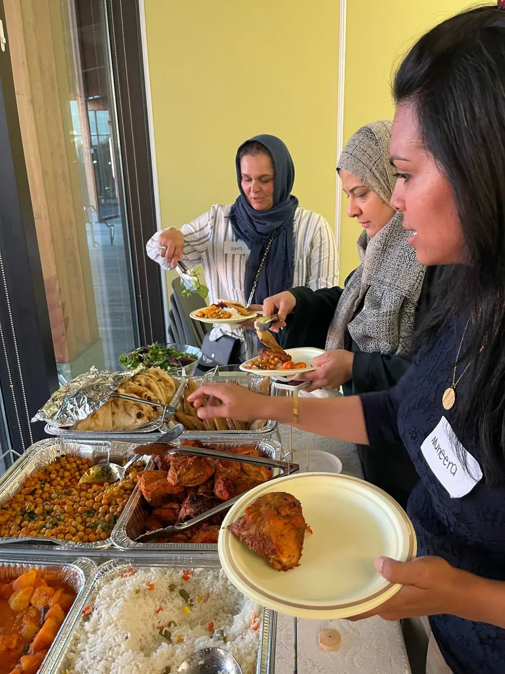Guests serving themselves dinner from trays of food